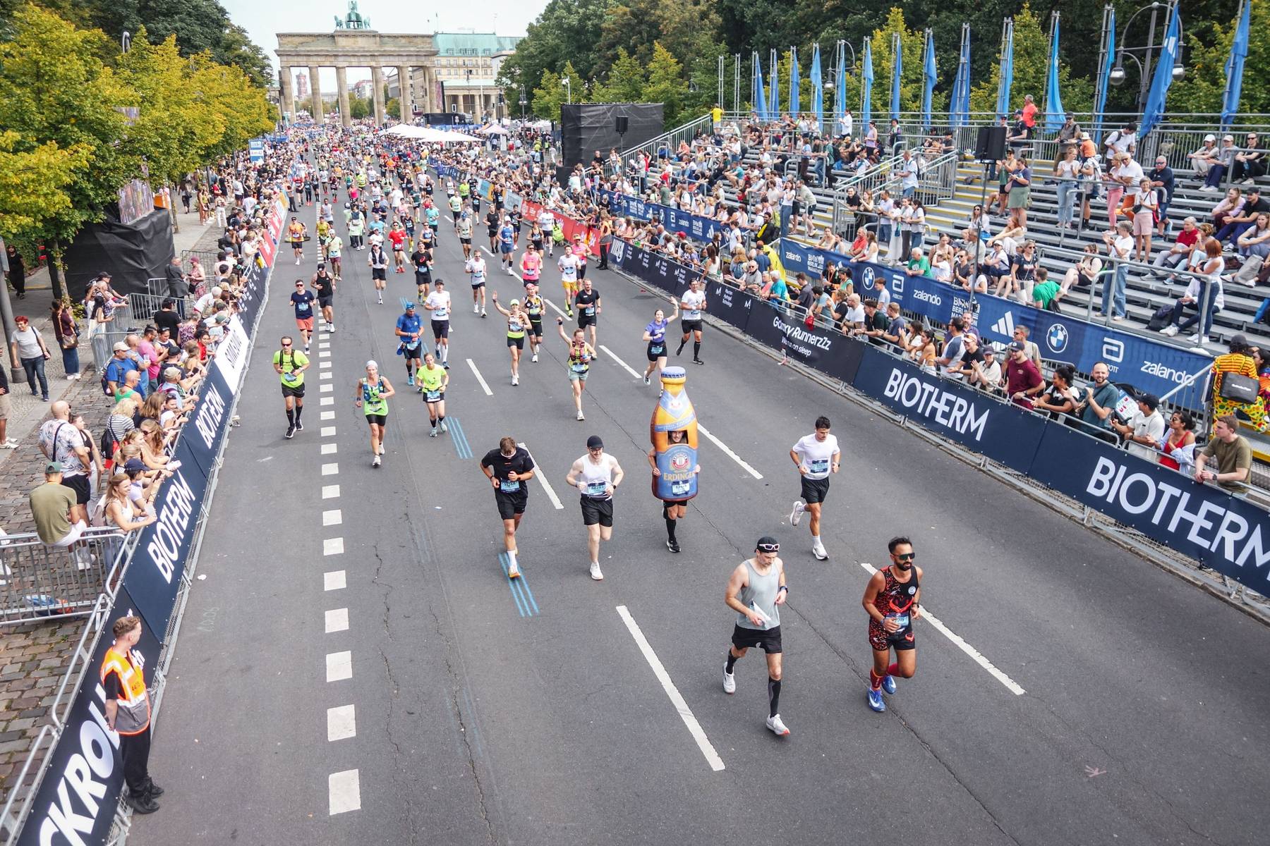 Blick von oben auf das Läuferfeld des Berlin-Marathons, im Hintergrund das Brandenburger Tor