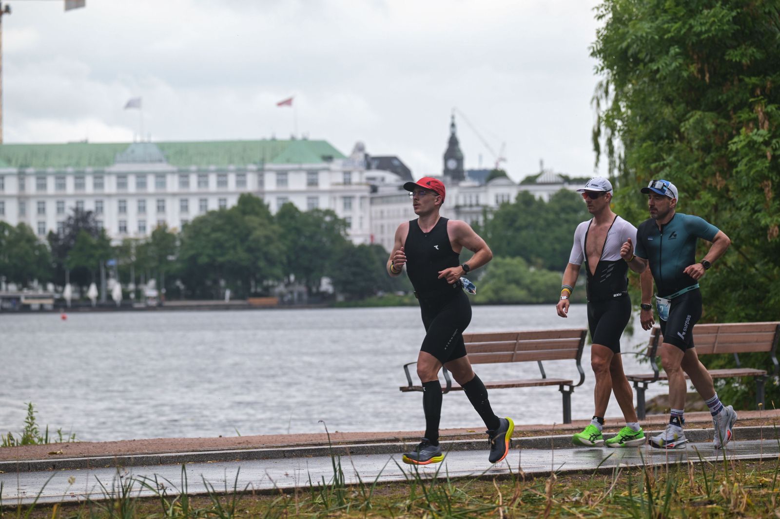 Lucas läuft am Ufer der Alster entlang, zwei weitere Athleten folgen, gegenüber liegt die Hotelzeile