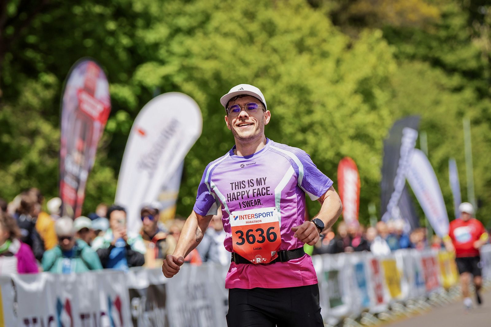 Lucas läuft lächelnd im violetten Trikot an Absperrgittern und Zuschauern vorbei