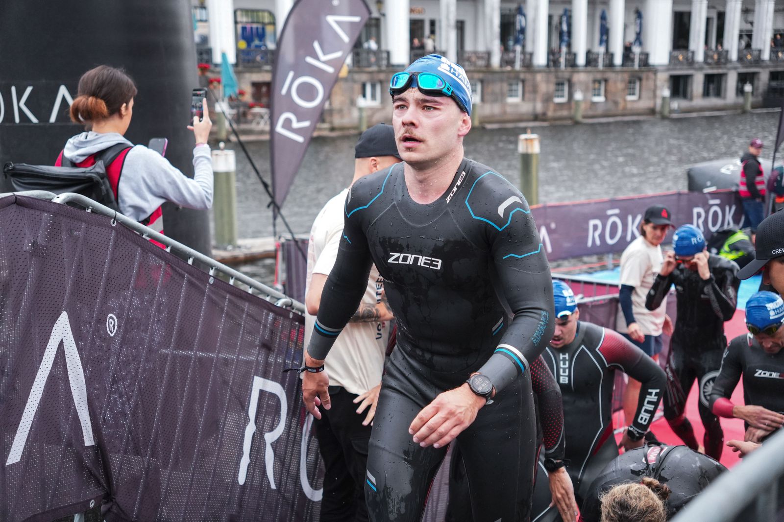 Lucas steigt im Neoprenanzug aus dem Wasser, die Schwimmbrille auf der Stirn