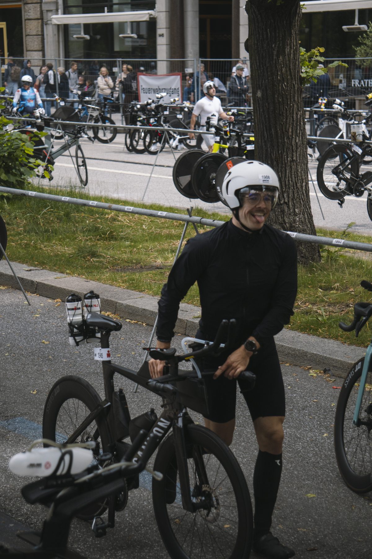 Lucas schiebt lachend sein Rad durch die Wechselzone, Zunge herausgestreckt